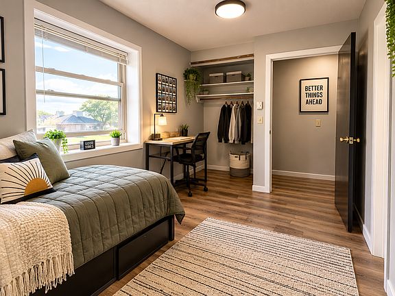 This cozy bedroom features warm flooring, a large window for natural light, and a convenient closet and shelving area. Perfect for creating your own personal retreat!