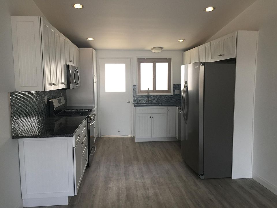 Gourmet kitchen with blue granite and top of the line chrome appliances plus beach glass backsplash and tons of soft close cabinets