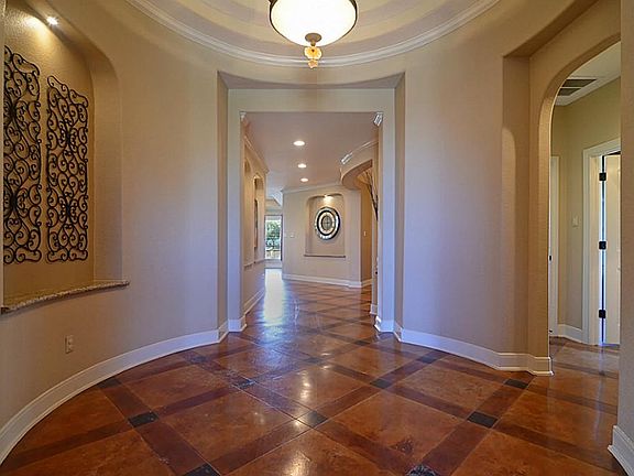 Impressive, the extended 38-foot long Foyer dazzles the eye with architectural excellence with an array of soft curves, right angles and vertical columns that accent the gallery of lighted art niches with granite bases.