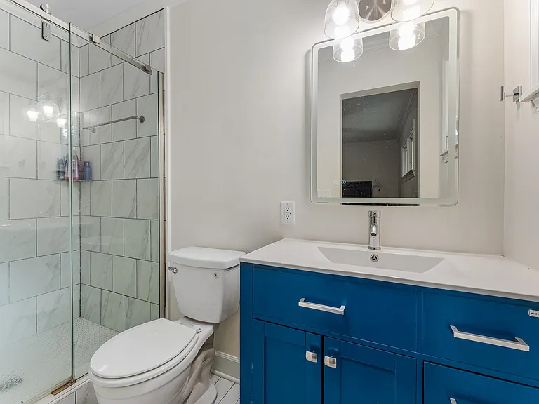 Primary bath features walk in shower, antifog and backlit vanity mirror