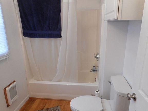 full bathroom with hardwood flooring, shower/tub enclosure, toile and vanity/sink