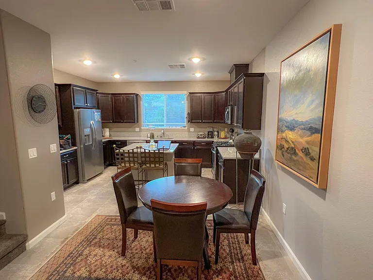 Dining area and kitchen. Kitchen is fully stocked w gas stove, dishwasher, full size refrigerator, dishes, utensils, coffee maker and everything needed.