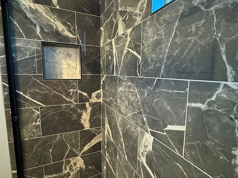 Guest bathroom with high glass, all tile and niche.