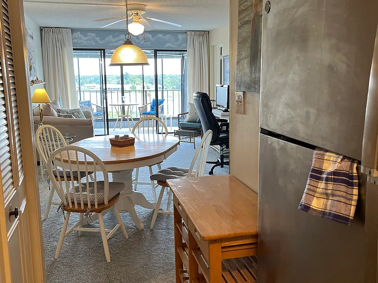 Looking from kitchen to dining area, living room and balcony.