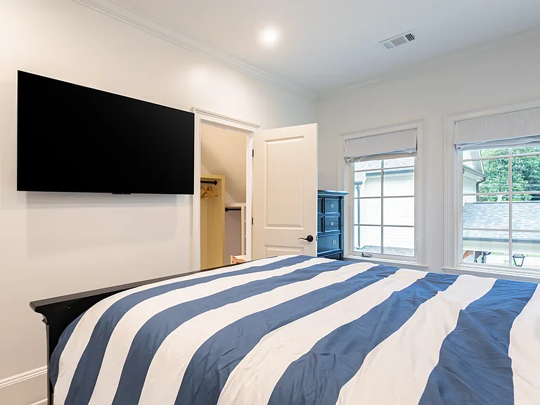 Bedroom with view of walk in closet and 55" TV.