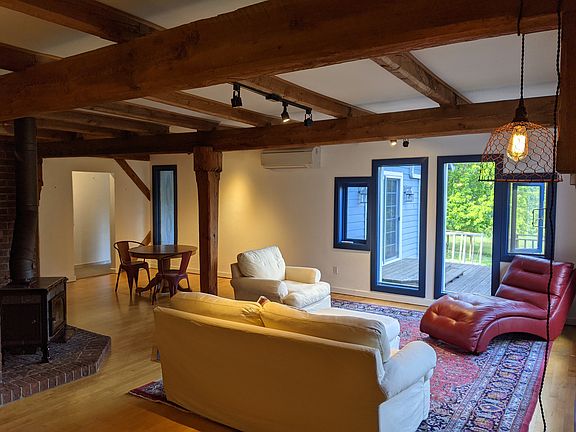 Spacious and bright open concept living area with soapstone wood stove