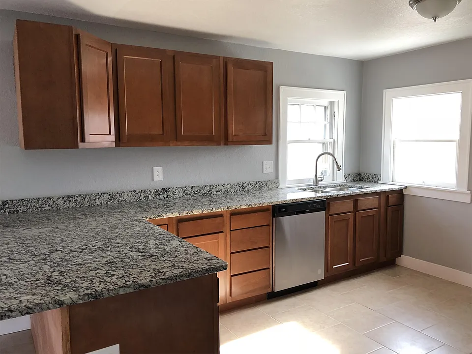 View of the kitchen which includes stainless steel dishwasher, oven, and refrigerator.