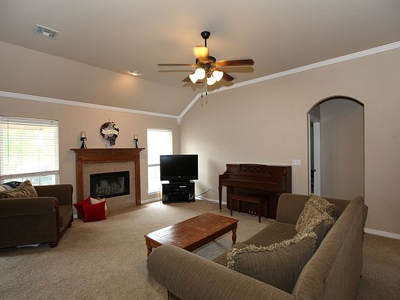 Living room with woodburning fireplace & crown molding.