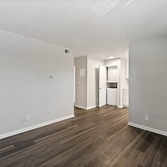Step into a contemporary living space with chic floors and convenient laundry amenities. - Bridgewood