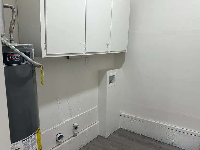 Laundry Room with washer and dryer hookups, nice cabinets and a place to hang clothes on hangers.