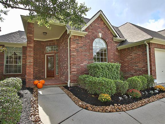 Curved walkway to large covered brick porch. Freshly landscaped and mulched.