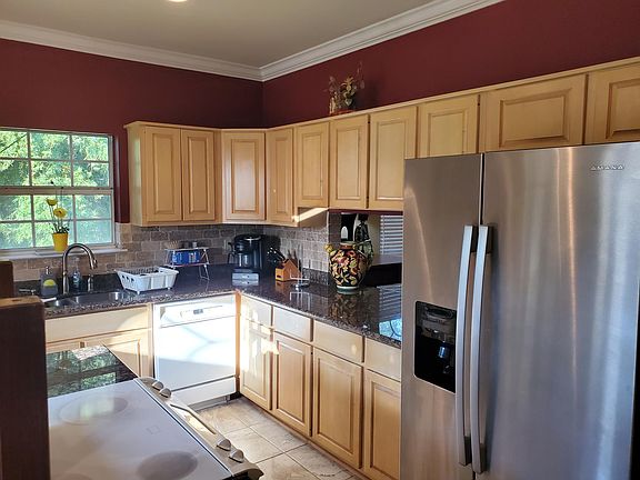 Kitchen with double sinks, dishwasher, conduction stove and range, side by side refrigerator/freezer and generous cabinetry.