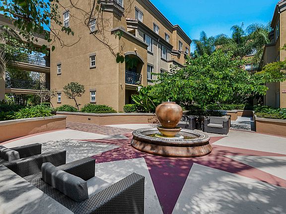 Community courtyard with a fountain and lounge seating surrounded by landscaped foliage.