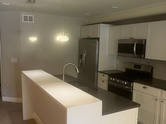 Kitchen with updated appliances, gas stove, microwave, island with faucet, updated cabinets.