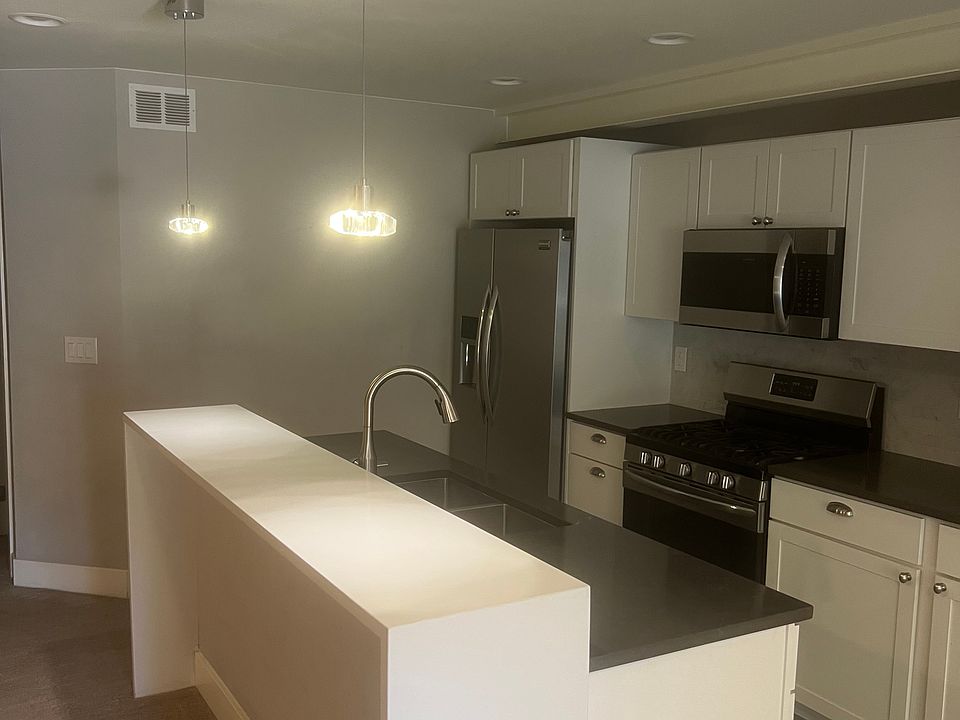 Kitchen with updated appliances, gas stove, microwave, island with faucet, updated cabinets.