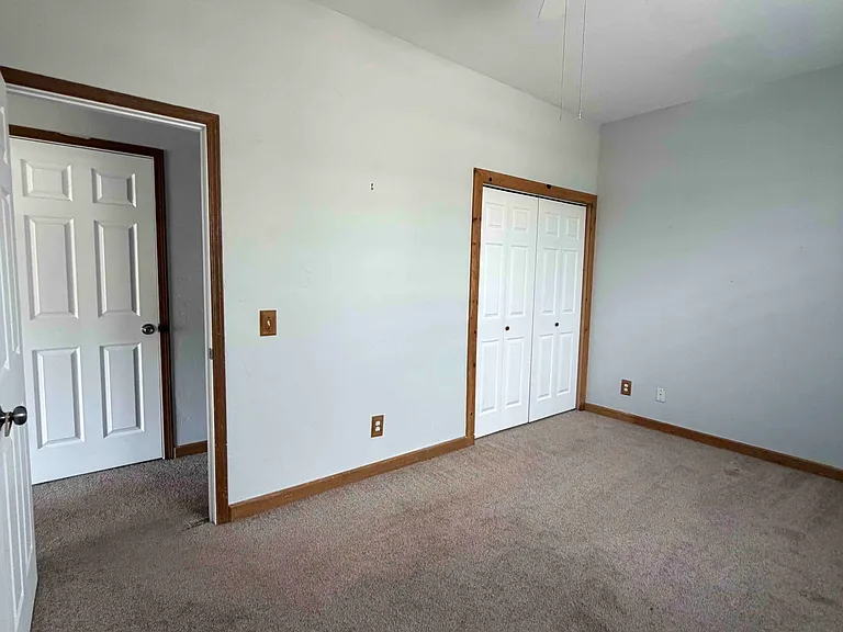 Bedroom has closet and ceiling fan, natural light from windows