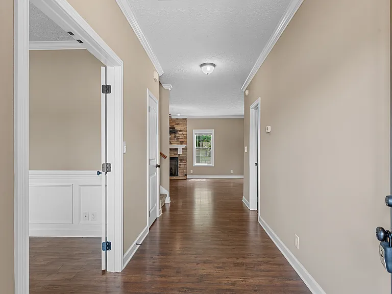 Entrance hallway, with office entrance at left, sizable coat closet next to stairs, and half bath to the right.