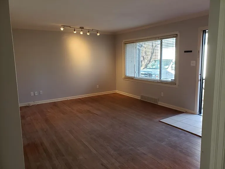 Huge living room. Hardwood floors have been refinished since this photo was taken. New blinds are in all windows throughout the house.
