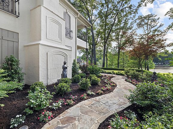 Winding flagstone pathway surrounded by lush landscaping and mature trees