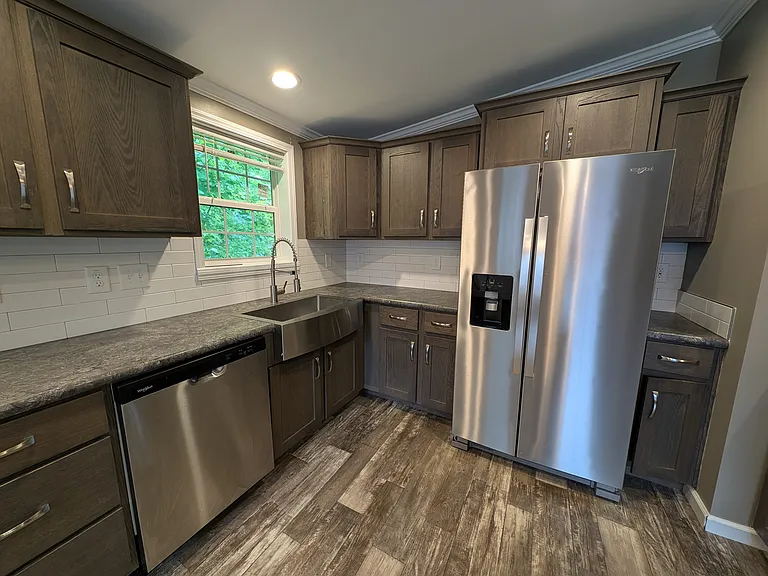 Side by Side fridge w icemaker, dishwasher, farmer sink, window above sink.