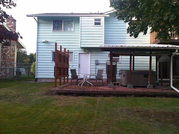 The back patio with covered hot tub and privacy screen.
