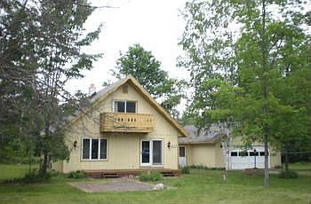 Take a Look! Home & garage on 1.67 acres. 3 bedroom 2 bath chalet style,  1073 sq ft on main floor, plus 2 large bedrooms upstairs. Appliances included. Natural gas heat. 24x36 attached garage.  Sets across the road from State land and close to lakes. Please call or e-mail for map, information sheet, aerial view and more pictures.