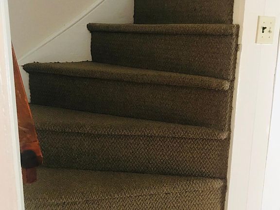 Curved Carpeted stairwell leading to 2nd floor.