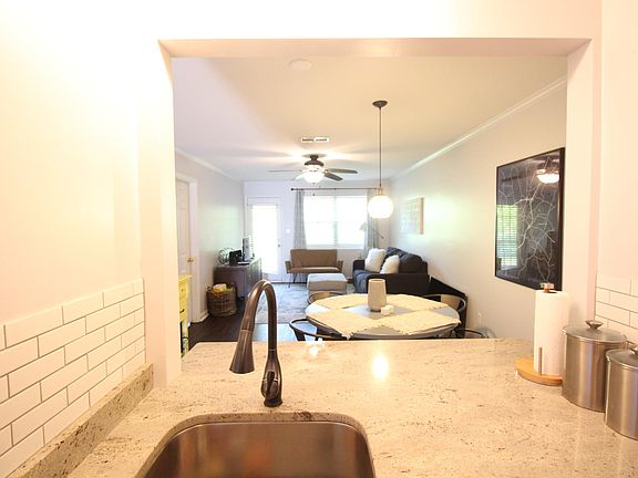 Kitchen bar looks into Dining and Living Room