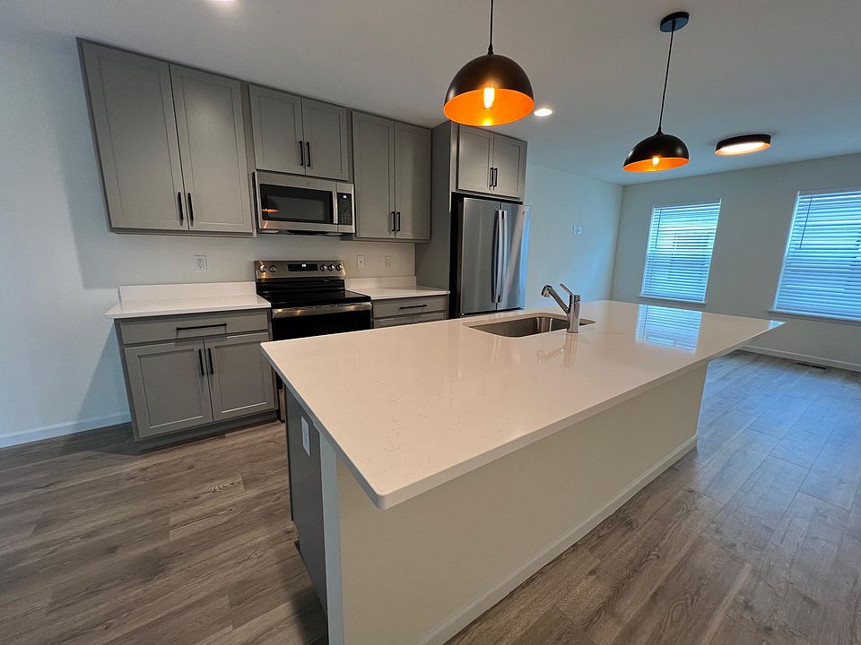 Kitchen with Quartz countertops upgraded lighting and fixtures and oversized island.
