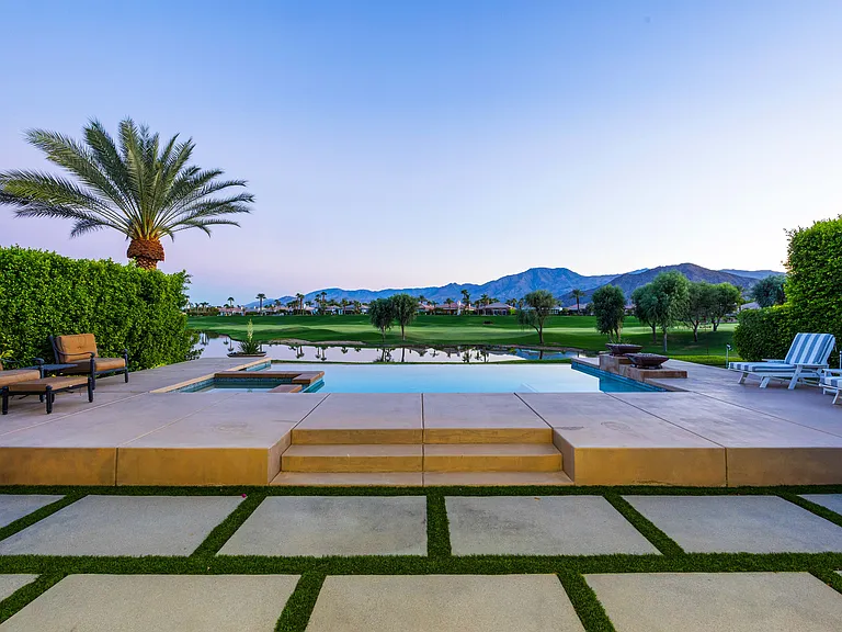 Evenings by the pool with panoramic mountain and fairway views. Pure desert luxury.
