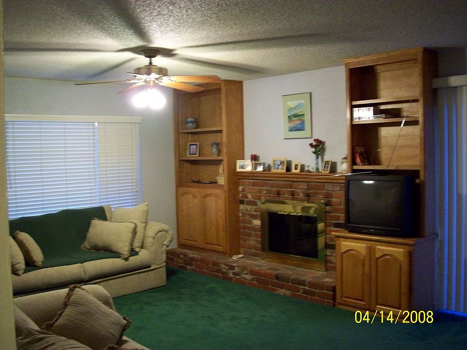 Living room has built in cabinets on both sides of the fireplace.