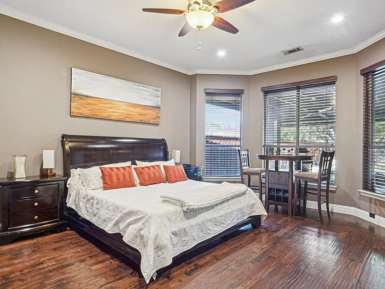 Primary bedroom with sitting area and pool views