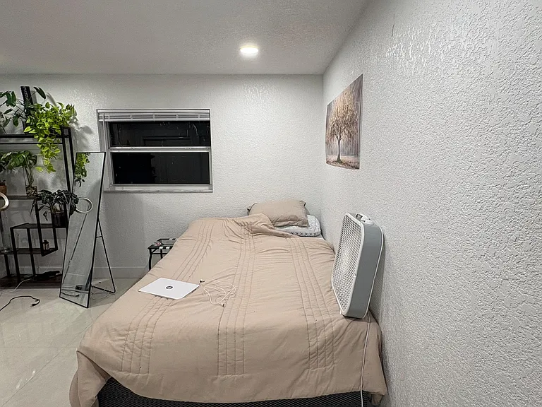 Private bedroom with tile floors, a window for ventilation, and space for a bed plus essentials.