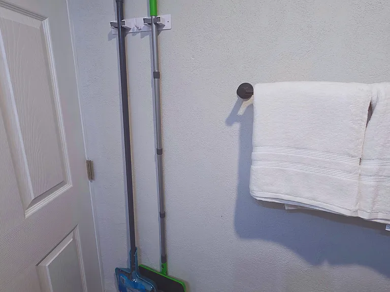 Wall-mounted mop and broom holder for easy cleaning storage