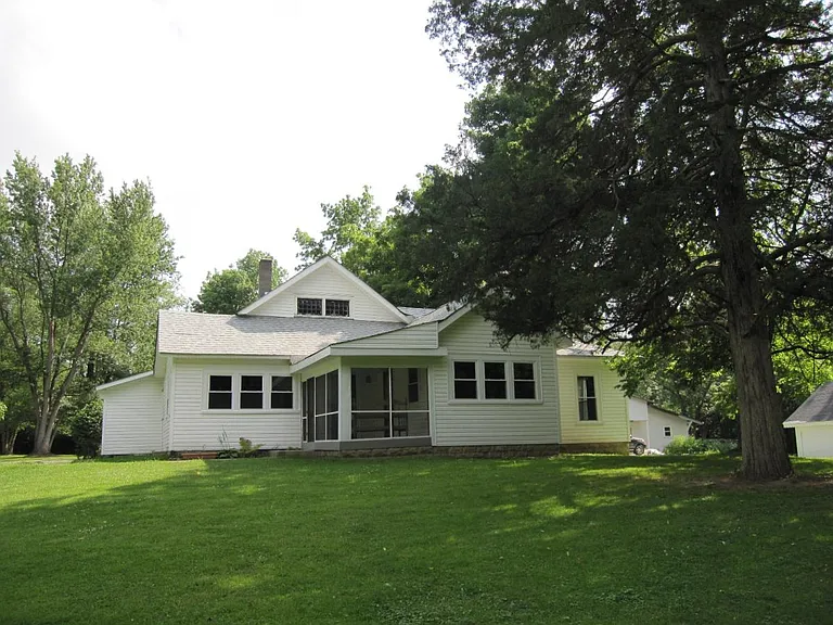 Front view of house on hill with spacious front yard.