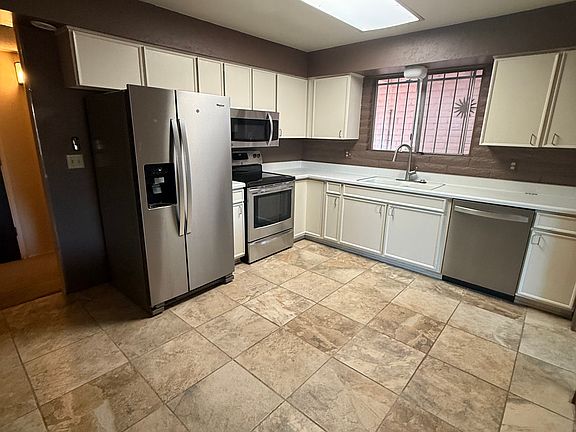 Spacious kitchen has all updated stainless steel appliances; room for either a dining table or kitchen island.