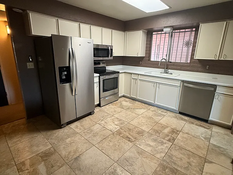 Spacious kitchen has all updated stainless steel appliances; room for either a dining table or kitchen island.