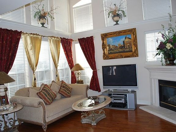 Spacious 2 Story living room, wall-to-wall windows, hardwood floors.