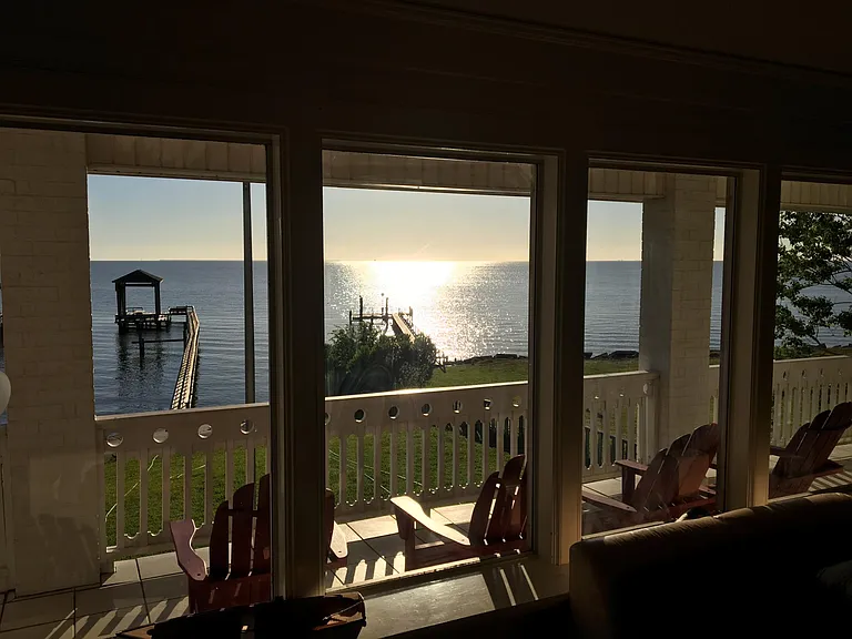 View of home's balcony, with the bay and pier in the background. **Please note that pier in background was damaged in hurricanes last summer.**