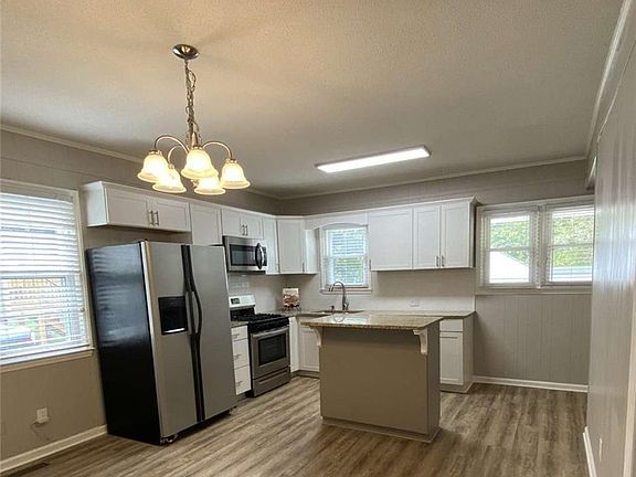 Bright kitchen with brand new stainless steel appliances.