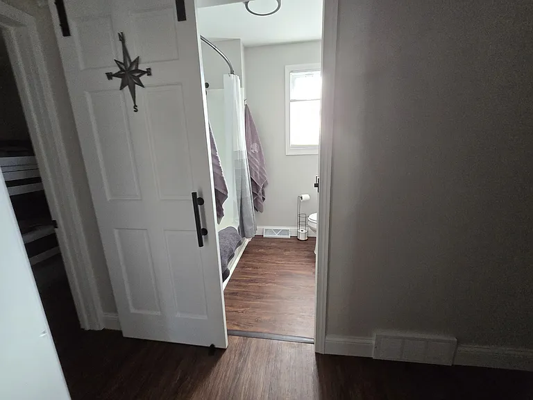 Bathroom, furnished with towels and bath mat.