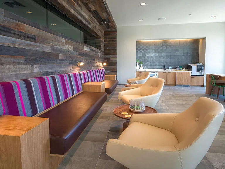 Lounge with wood-paneled walls and colorful seating for a cozy retreat.