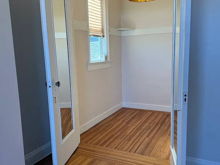 Bedroom without furniture. Mirrors on french doors. Corner shelving. Dimmer chandelier. Tenant can paint/design to their style.