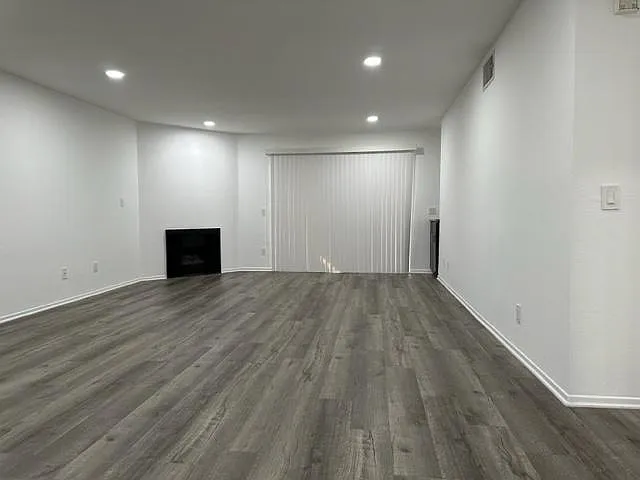 Large living room with recessed lighting and fireplace.