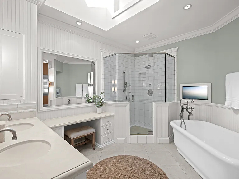 Primary Bathroom with two sinks, vanity, plenty of storage, TV, shower with dual shower heads and bath tub
