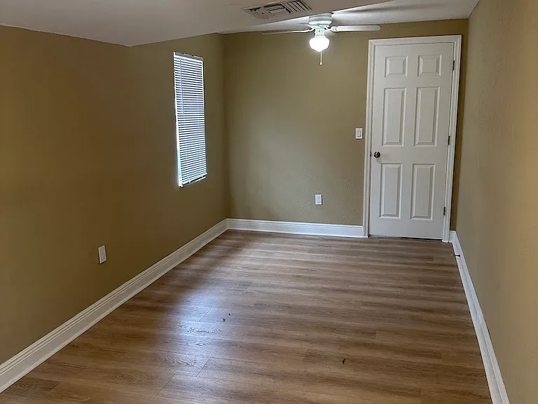 Primary bedroom with new plank flooring and separate entrance.