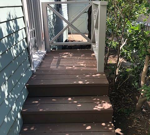 Side of home with an exterior door into the extra space that can be used as an office or TV room