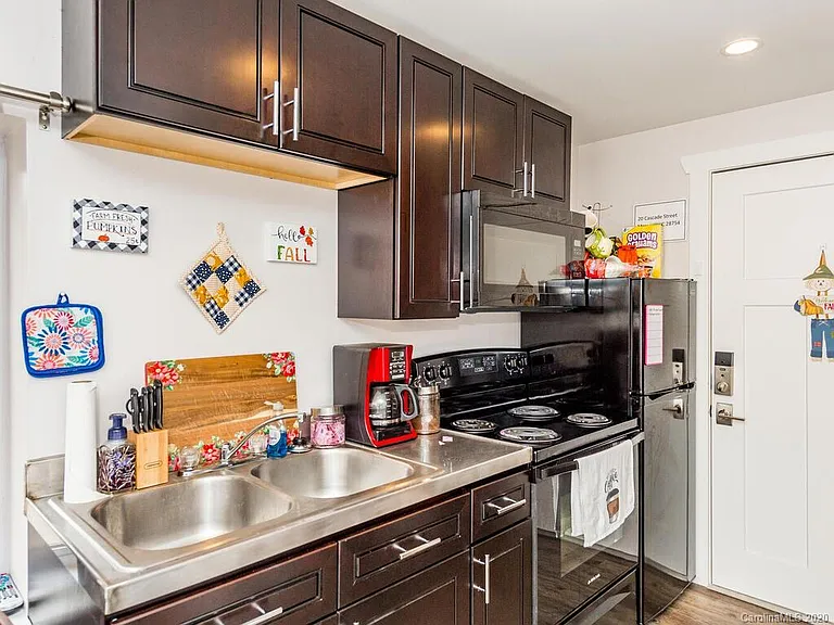 Kitchen area with oven, microwave and refrigerator.