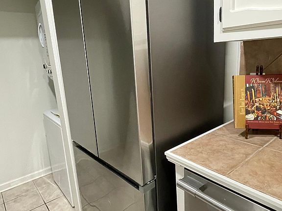New refrigerator with ice maker and adjacent dishwasher.