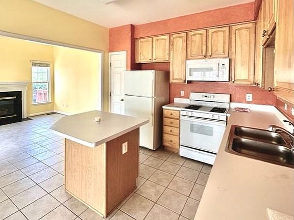 level 2: Kitchen with an island open to family room w Fireplace - New fridge and microwave.
